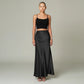 Model wearing a Lavishly Me black satin maxi skirt with a matching black crop top and embellished heels.