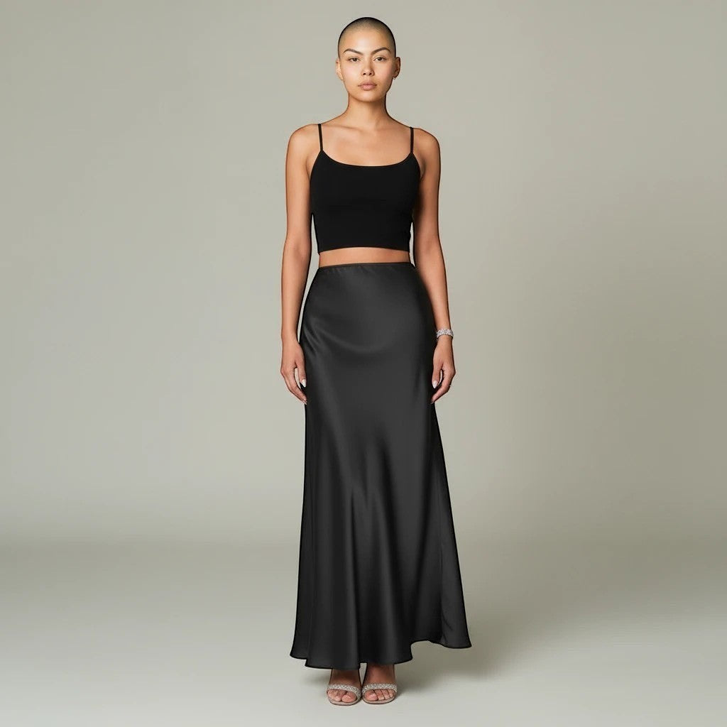 Model wearing a Lavishly Me black satin maxi skirt with a matching black crop top and embellished heels.