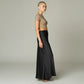 Model wearing a Lavishly Me black satin maxi skirt with a beige cropped t-shirt in a side profile view.