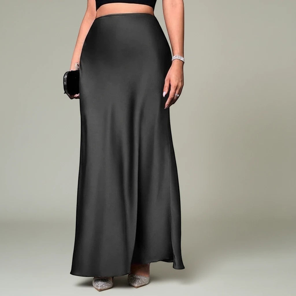 Lavishly Me Riviera black satin maxi skirt with a fluid, floor-length silhouette worn with heels and a clutch.