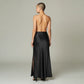 Model wearing a Lavishly Me black satin maxi skirt with a side slit, viewed from the back.