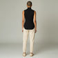 Back view of a model wearing a black Lavishly Me sleeveless ribbed turtleneck top with beige joggers
