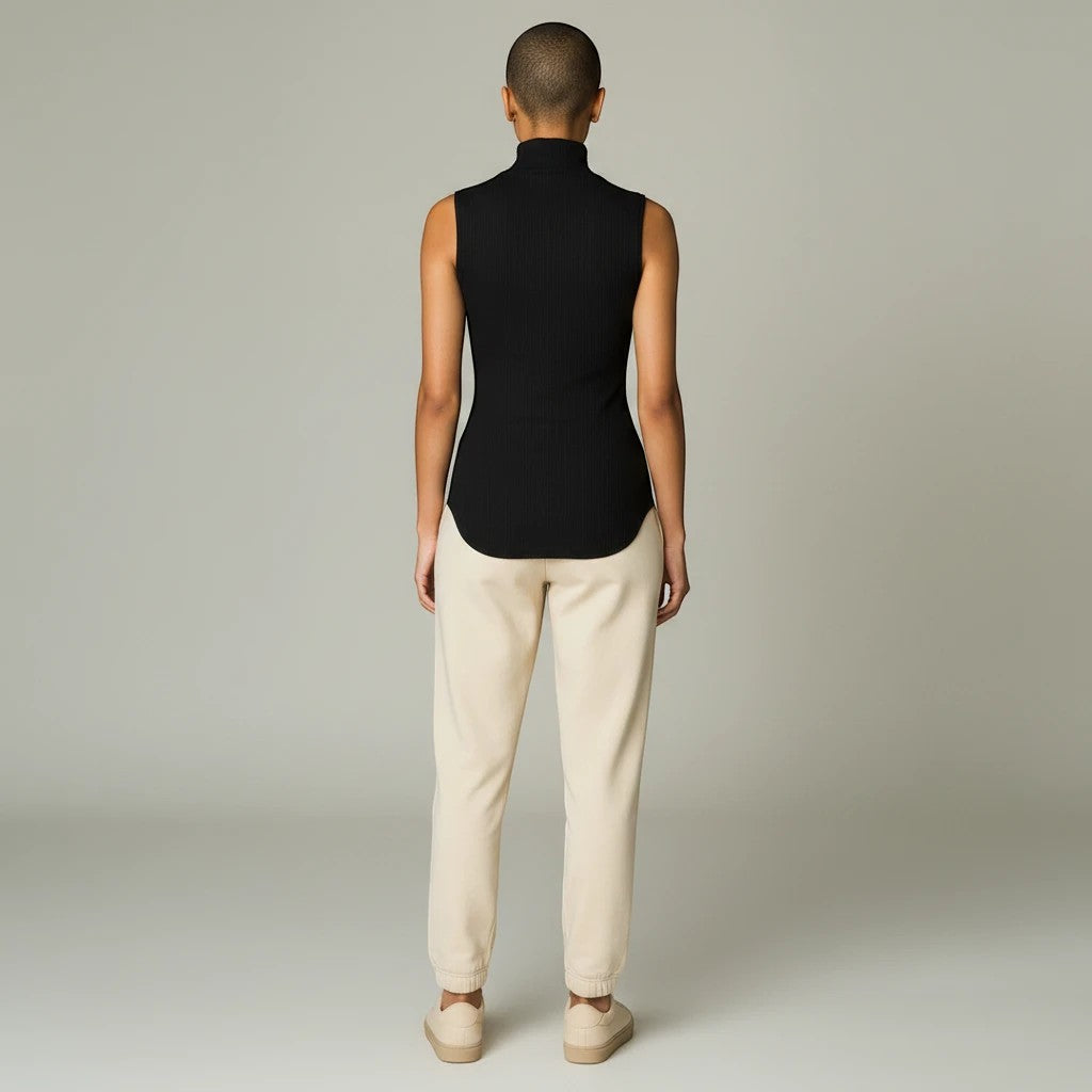 Back view of a model wearing a black Lavishly Me sleeveless ribbed turtleneck top with beige joggers
