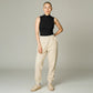 Model wearing a black Lavishly Me sleeveless turtleneck top with beige joggers and sneakers in a studio setting.