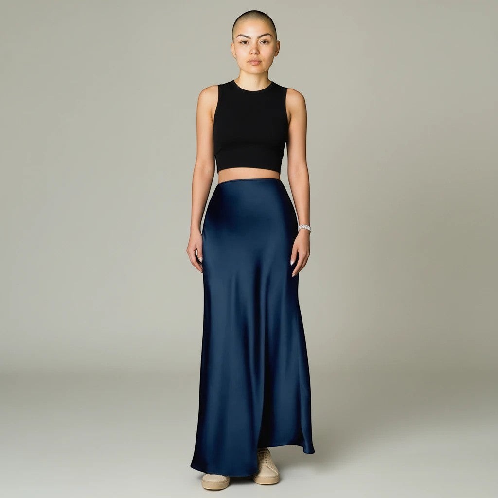 Model wearing a Lavishly Me navy blue satin maxi skirt with a black sleeveless crop top against a neutral background.