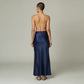 Model wearing a Lavishly Me navy blue satin maxi skirt with a fluid, floor-length silhouette, back view.