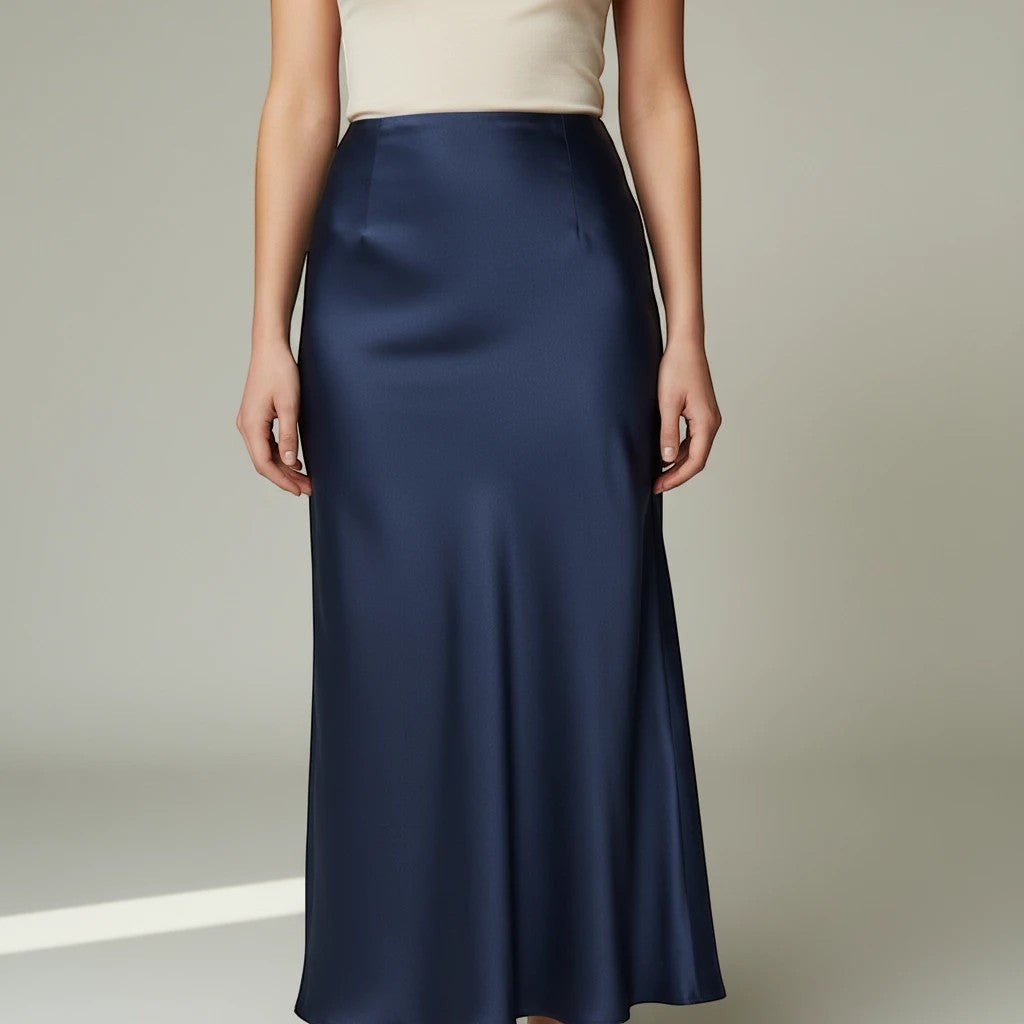 Lavishly Me navy blue satin maxi skirt with a fluid, minimalist silhouette worn with a cream top.