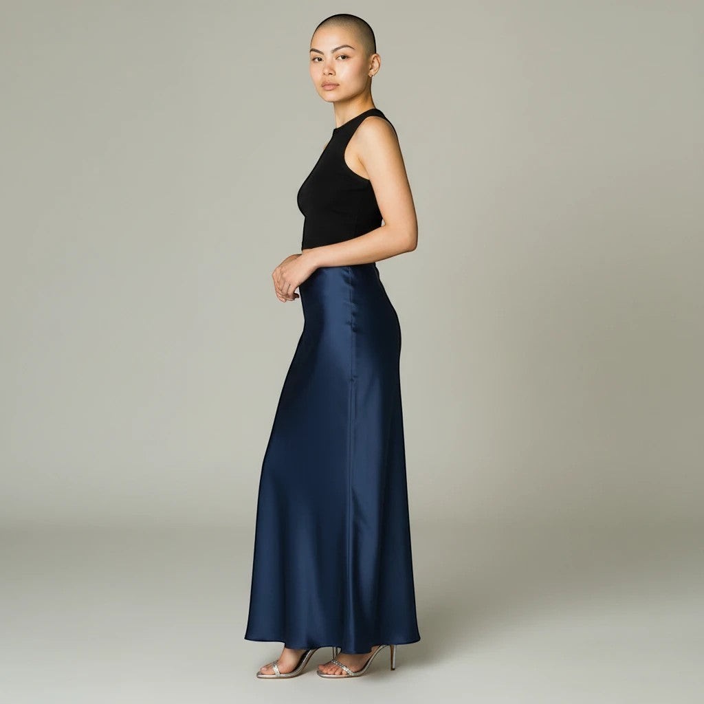 Model wearing a Lavishly Me navy blue satin maxi skirt with a black sleeveless top and metallic heels