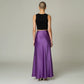 Model wearing a Lavishly Me purple satin maxi skirt with a black sleeveless top, back view