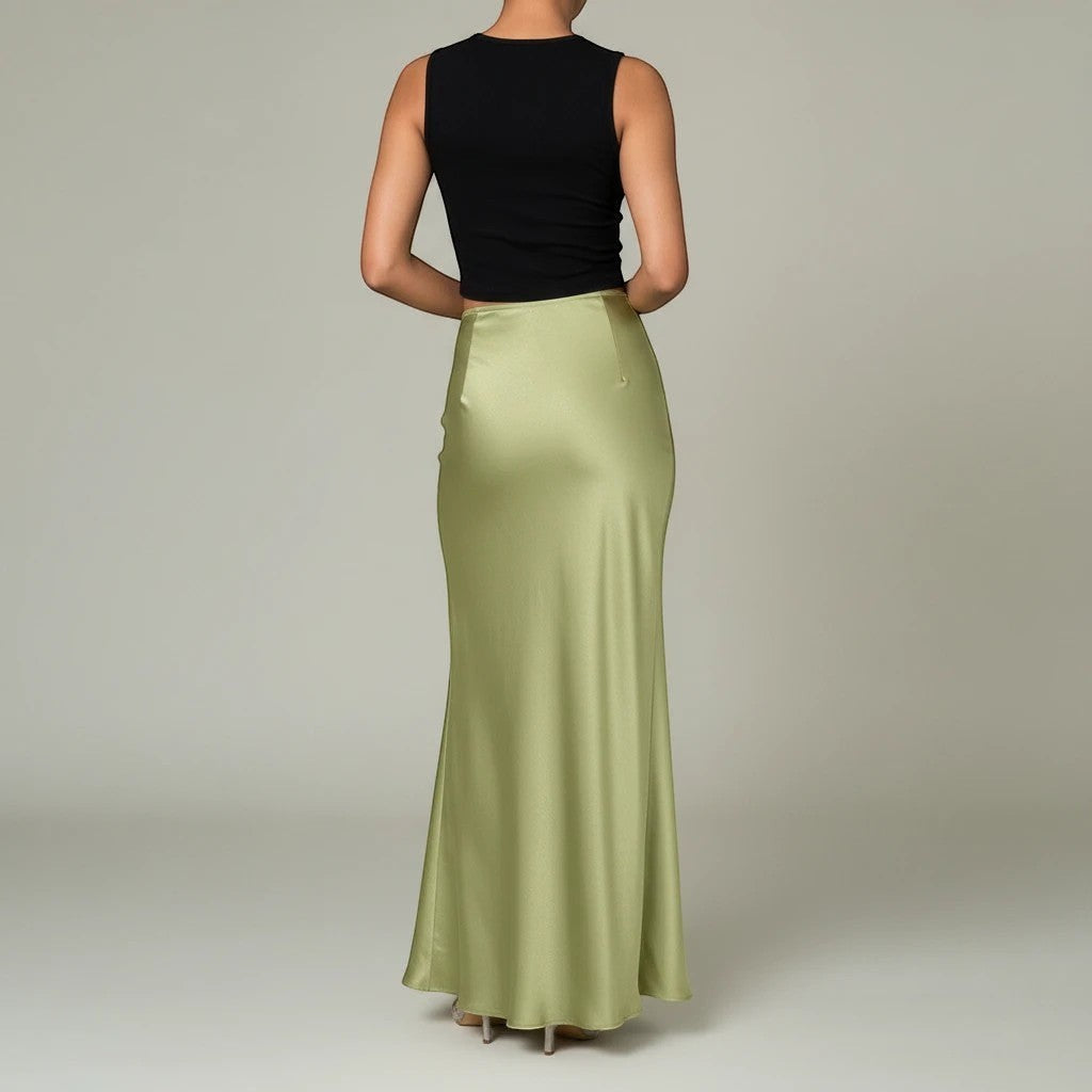 Back view of a woman wearing a Lavishly Me sage green satin maxi skirt paired with a black sleeveless top.