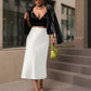 Lavishly Me white satin fishtail skirt worn by a woman with a black crop top and leather jacket on a city street.